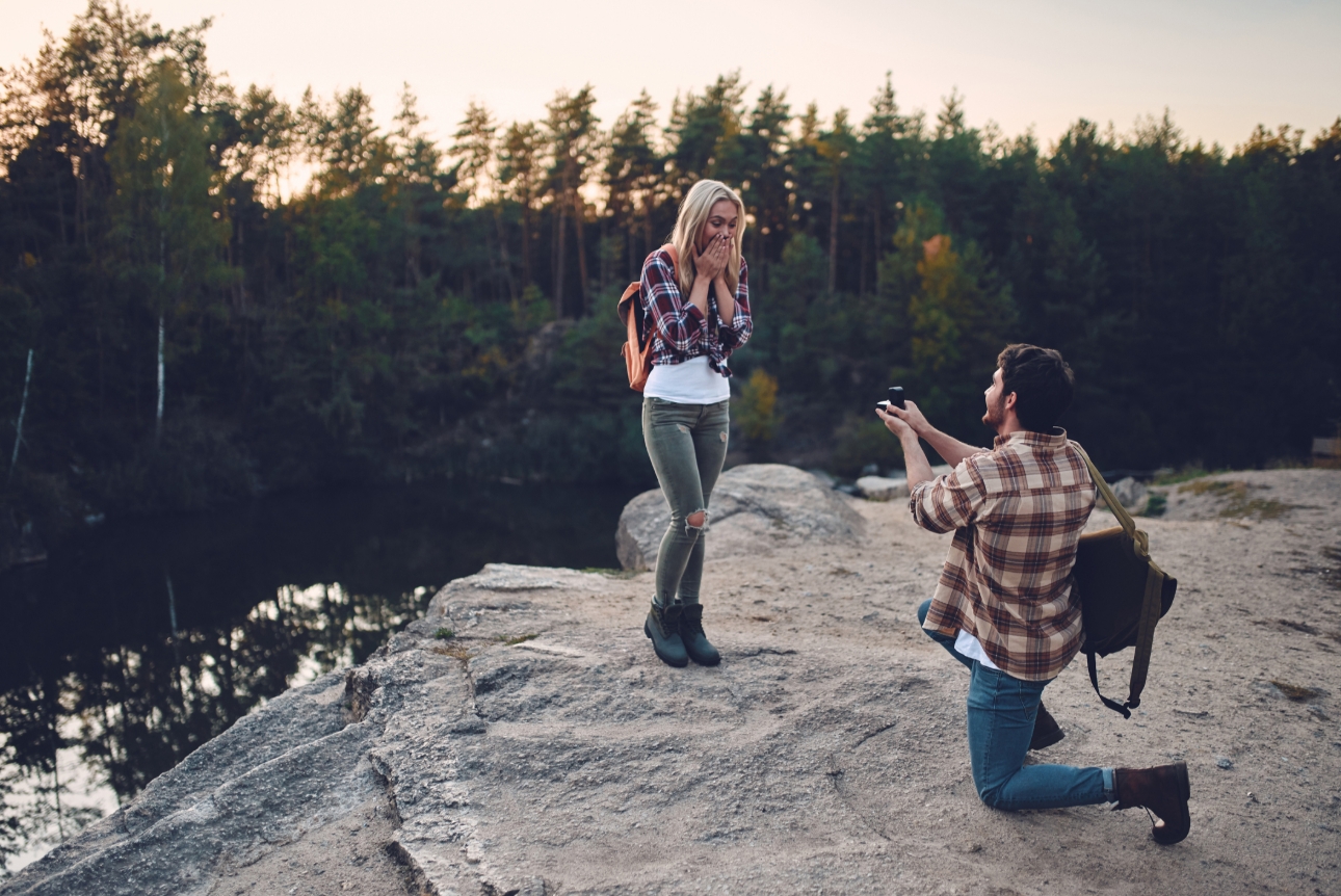 Man proposes to woman at sunset in the great outdoors