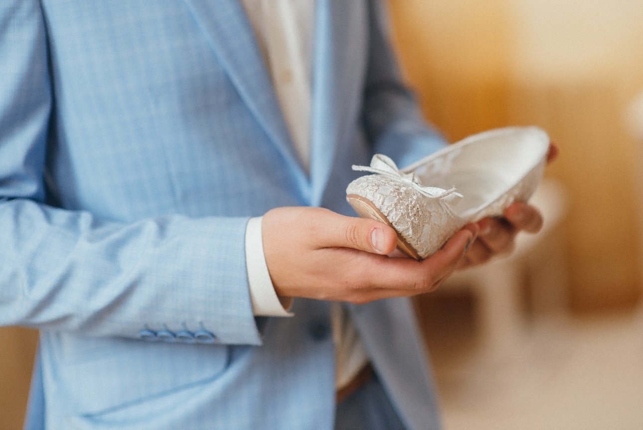 man in suit holding shoe