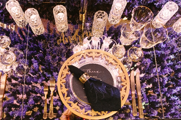 table setting with crystal glassware and purple blooms