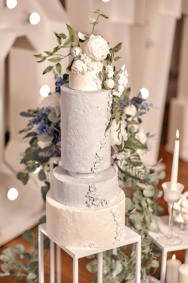 three tier wedding cake topped with white sugar flowers