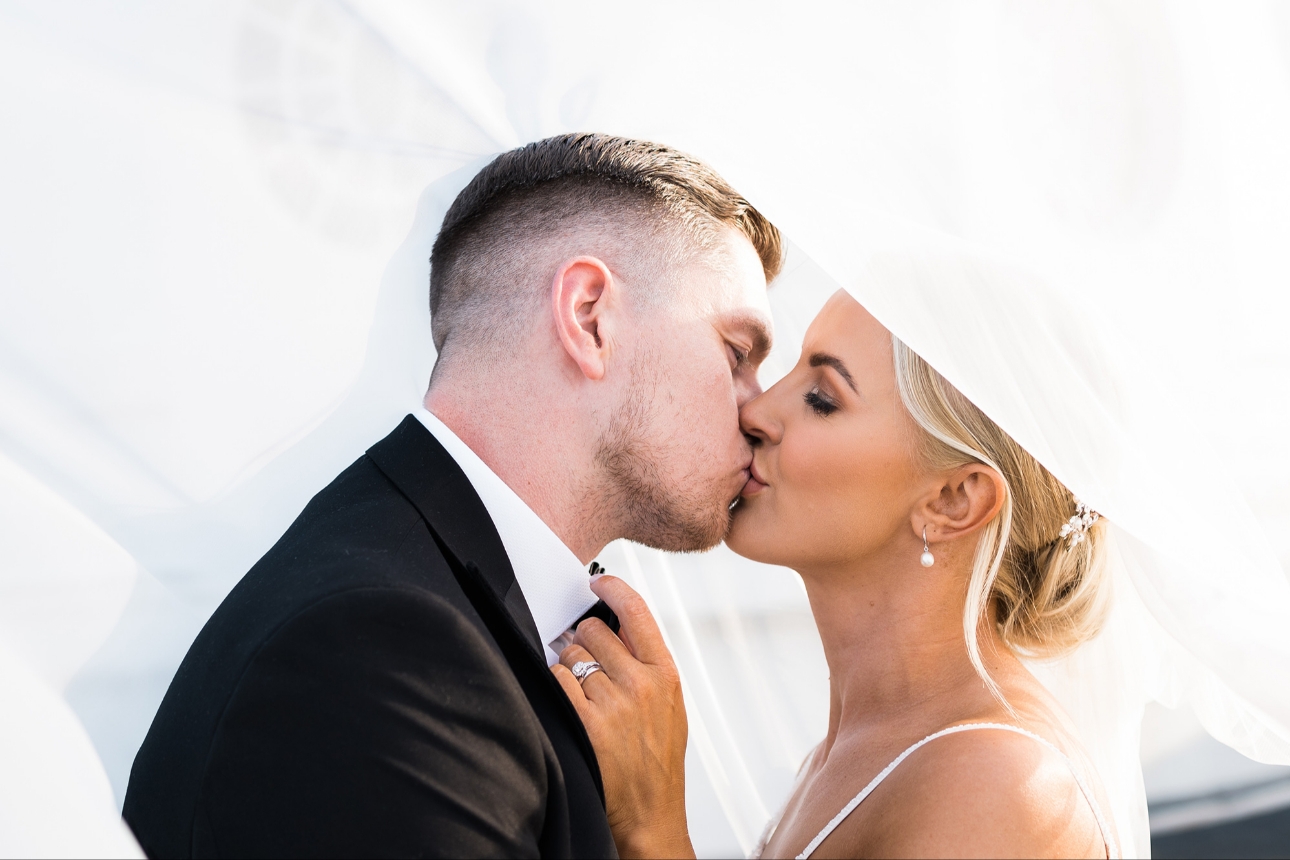 Couple kiss under bride's veil