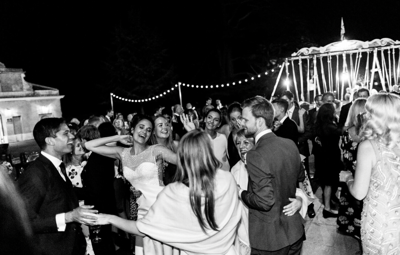 black and white photo of wedding party dancing on a boat