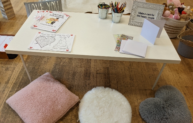 table with colouring on it and cushions on the floor as seats