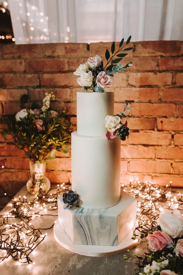 three tiered cake, two white tiers one hexagonal marbled tiered 