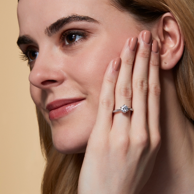 woman with hand on face wearing diamond ring