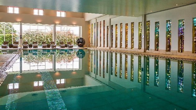 pool area with stained glass windows along one wall and panoramic windows the other