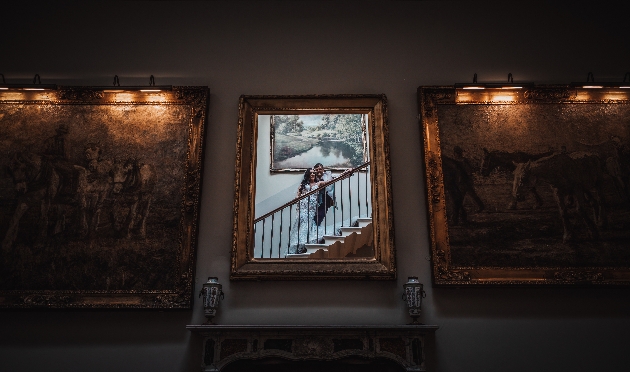 couple on stairs looking in mirror on a wall or artwork