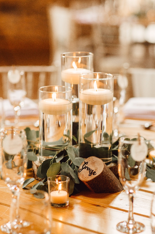 candles in vases with water on tables