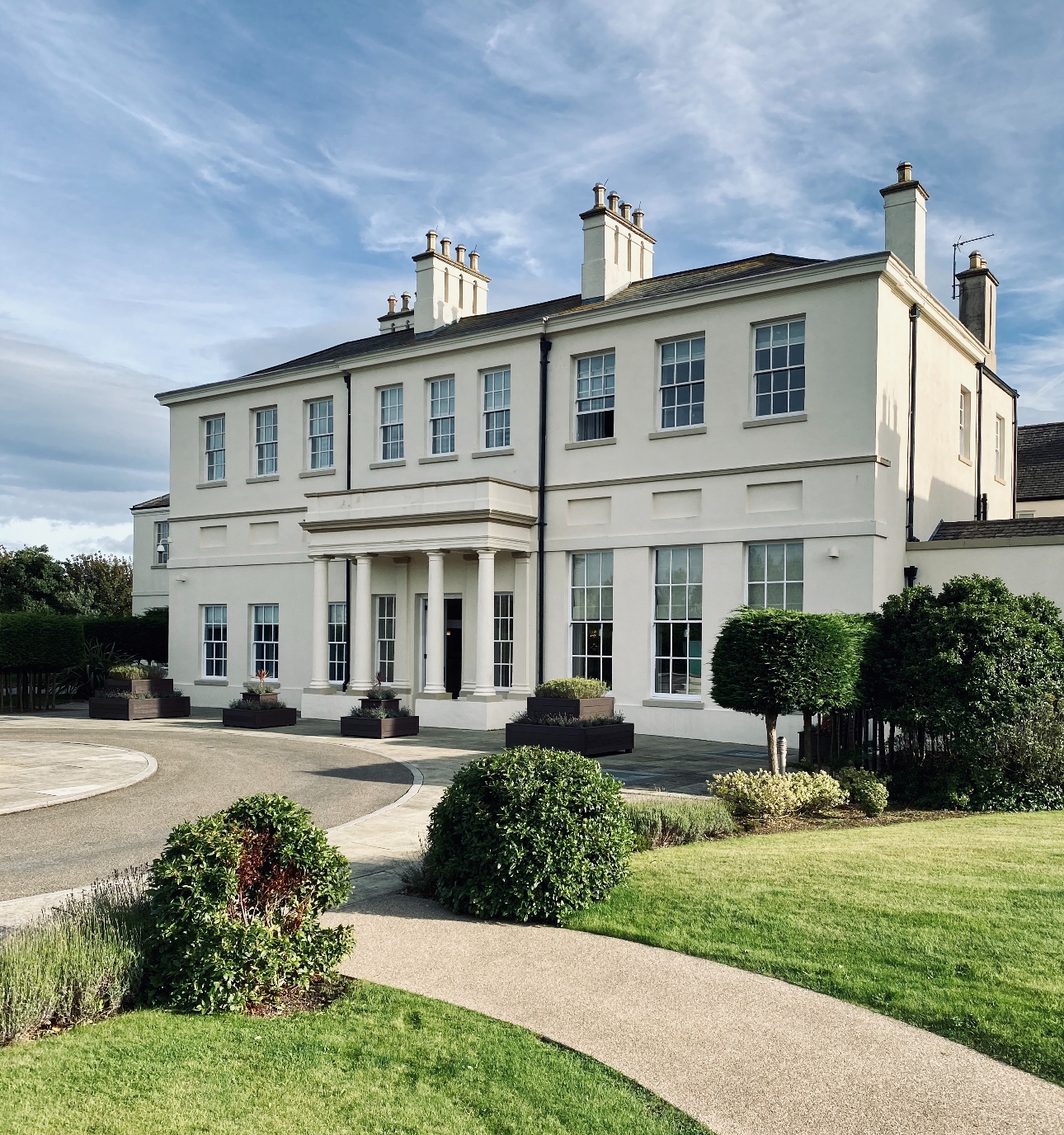 Seaham Hall white mansion with grass and paths surrounding it on sunny day