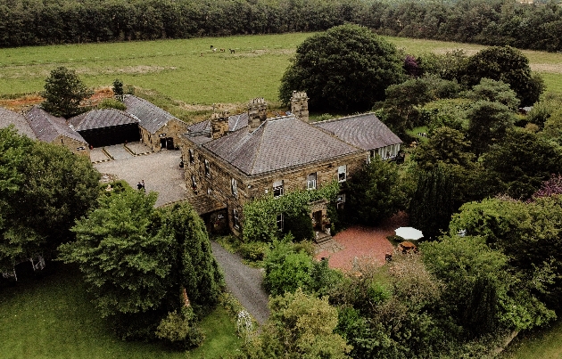 A birds eye view of a grand country house and surrounded countryside