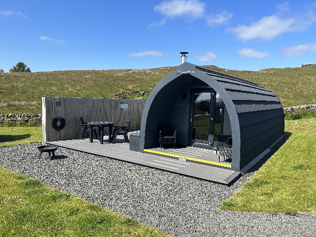 The exterior of a black glamping pod
