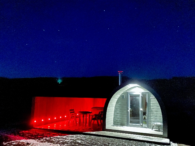 The exterior of a glamping pod at night