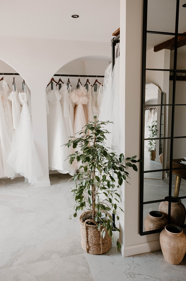 New Bridal Boutique white walls with black rails filled with modern dresses