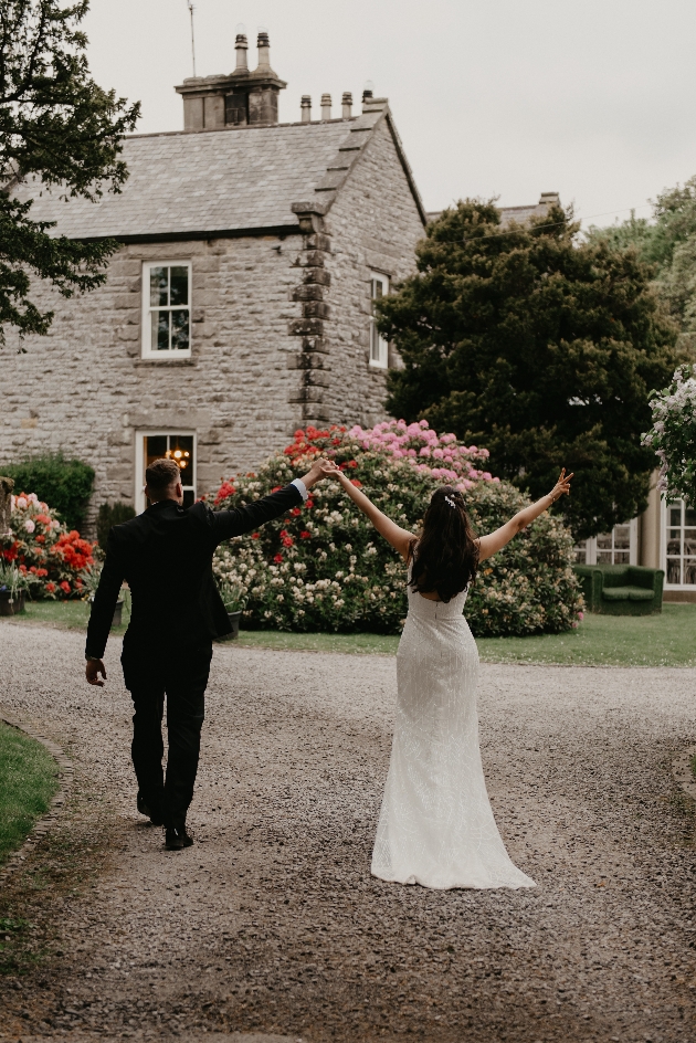 A bride and groom walking towards a venue